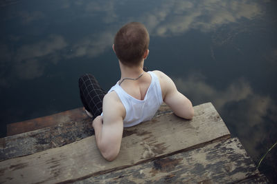 High angle view of boy sitting on wood