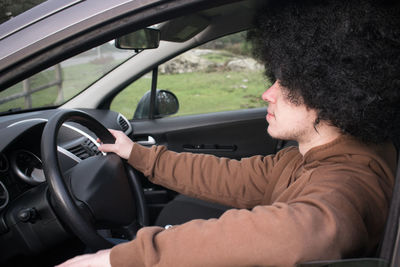 Side view portrait of man sitting in car