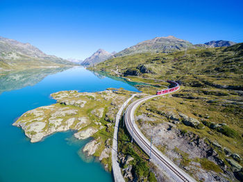 Scenic view of lake and mountains against clear blue sky