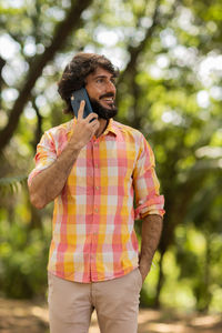 Young man at park on a beautiful sunny day with mobile phone.  working  leisure. green and nature 