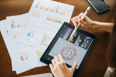 Midsection of woman using digital tablet at office