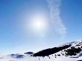 Scenic view of snowcapped mountains against sky on sunny day