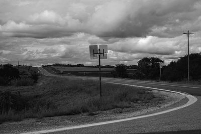 Empty road on field against sky