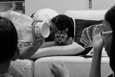 Close-up of family playing with cat at home