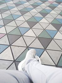 Low section of man on tiled floor