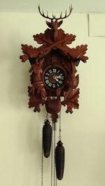 Low angle view of clock hanging against wall