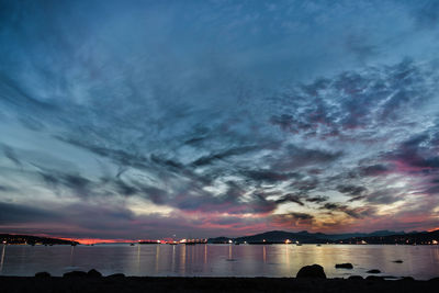 Scenic view of sea against dramatic sky during sunset