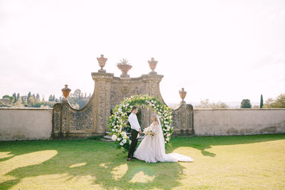 Full length of bridegroom against sky