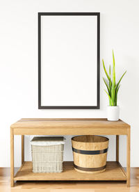 Potted plant on table against wall at home