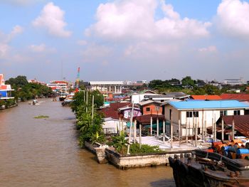 Boats in river against buildings in city