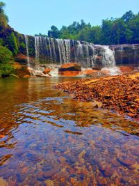 Scenic view of waterfall in lake