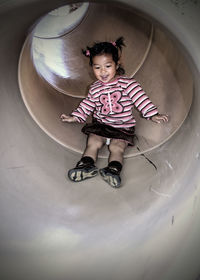 Girl playing on slide in playground