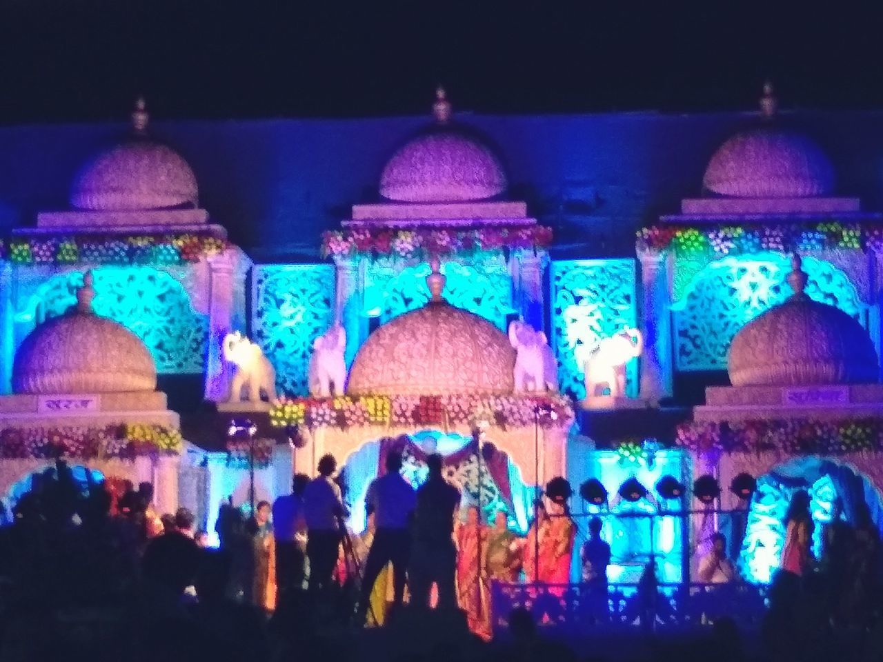 GROUP OF PEOPLE IN ILLUMINATED TRADITIONAL CLOTHING