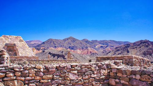 Scenic view of mountains against blue sky