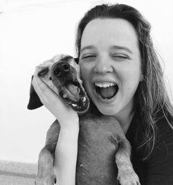 Happy woman screaming while holding dog