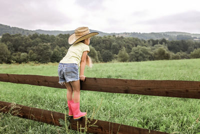 Full length of woman wearing hat on field