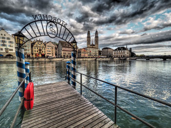 View of boats in river against cloudy sky