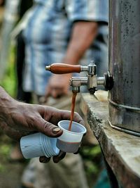 Tea pouring in disposable cup held by man