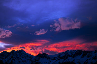 Scenic view of mountains against cloudy sky during sunset