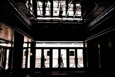 Silhouette of man standing in bus