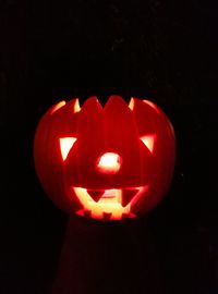 Close-up of illuminated halloween pumpkin against black background