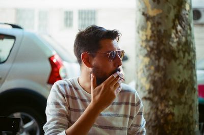 Close-up of man smoking cigarette on tree
