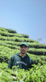 Portrait of young man standing amidst plants