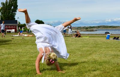 Rear view of girl practicing cartwheel at park