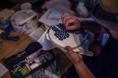 Midsection of woman making embroidery on fabric