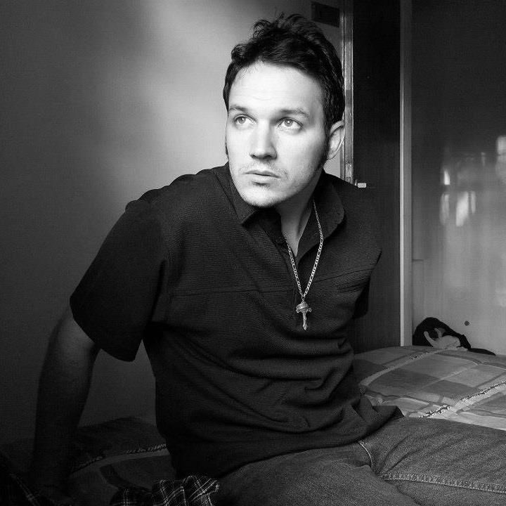 PORTRAIT OF YOUNG MAN AGAINST WALL AT HOME