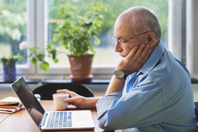 Senior man using laptop at home