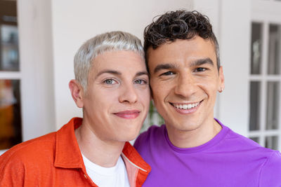 Portrait of happy young gay couple in love looking at camera