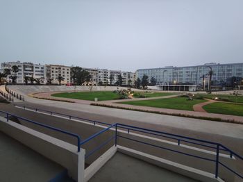 Empty road by buildings against clear sky