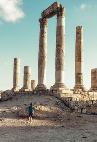 Full length of man on old ruin against sky