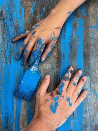 Close-up of hands on blue wood