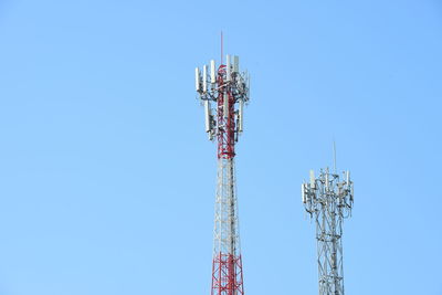 Low angle view of communications tower against blue sky