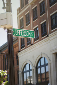 Low angle view of road sign against building
