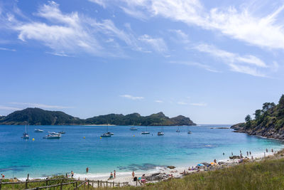 Panoramic view of people on beach against sky