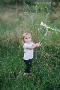 Portrait of boy standing on grassy field