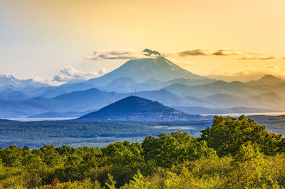 Scenic view of sea and mountains against sky at sunset