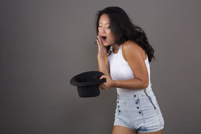 Portrait of young woman standing against wall