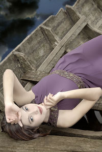 Portrait of woman lying down on wood