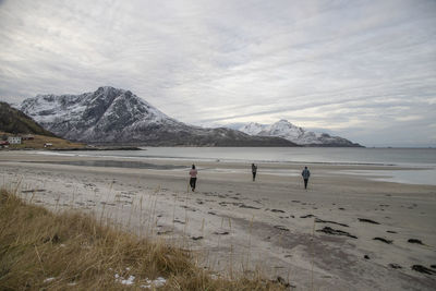 Rear view of people at beach during winter