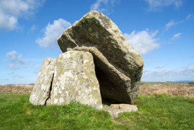 View of rocks on field against sky