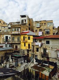 Buildings in residential district against cloudy sky