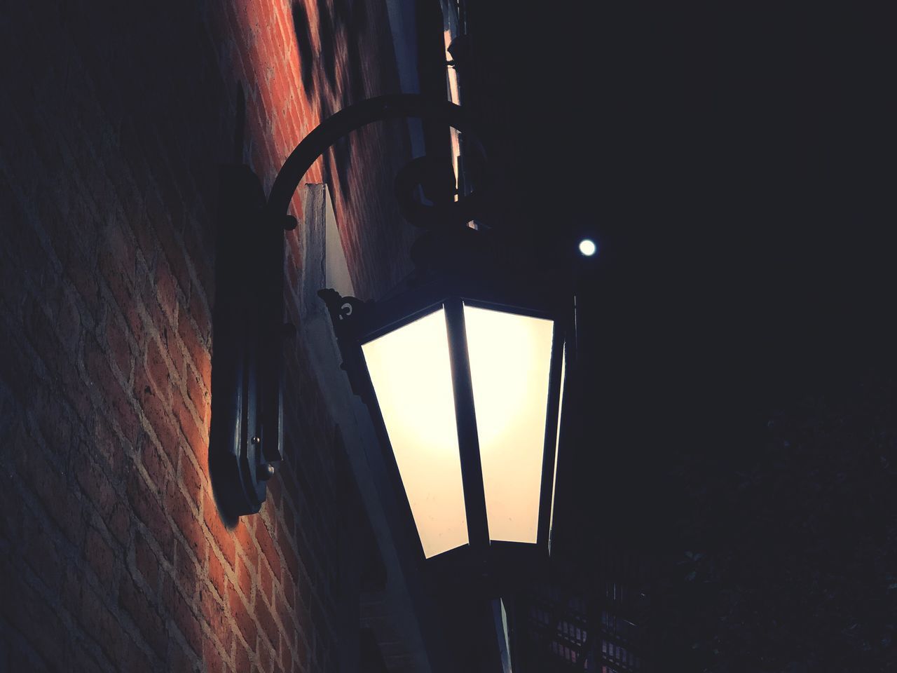 LOW ANGLE VIEW OF ILLUMINATED LIGHT BULB ON WALL