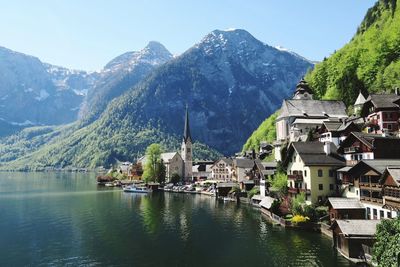 Scenic view of townscape by mountain against sky