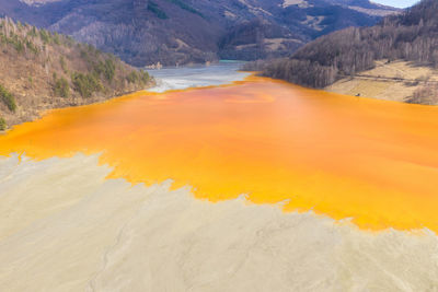 Colorful lake polluted with yellow waste water, aerial view of a mining decanting pond 