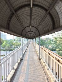 Empty elevated walkway in city during sunny day