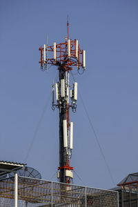 Low angle view of communications tower against clear blue sky